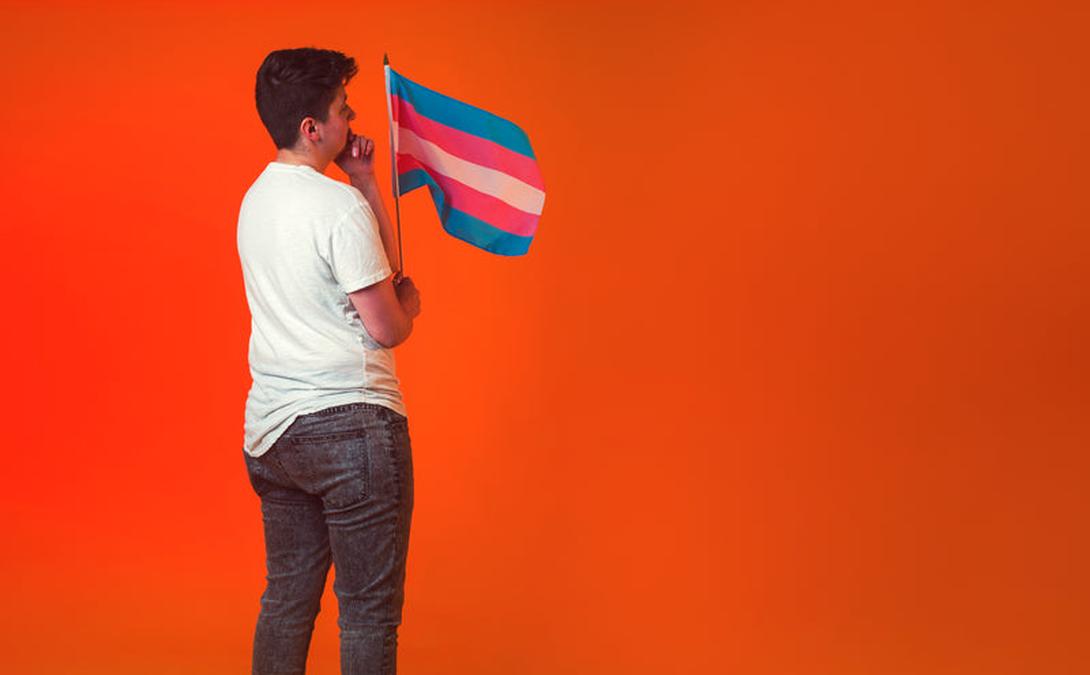 pensive androgyne holding trans pride banner - Image of Digital Marketing, "Builderall features"