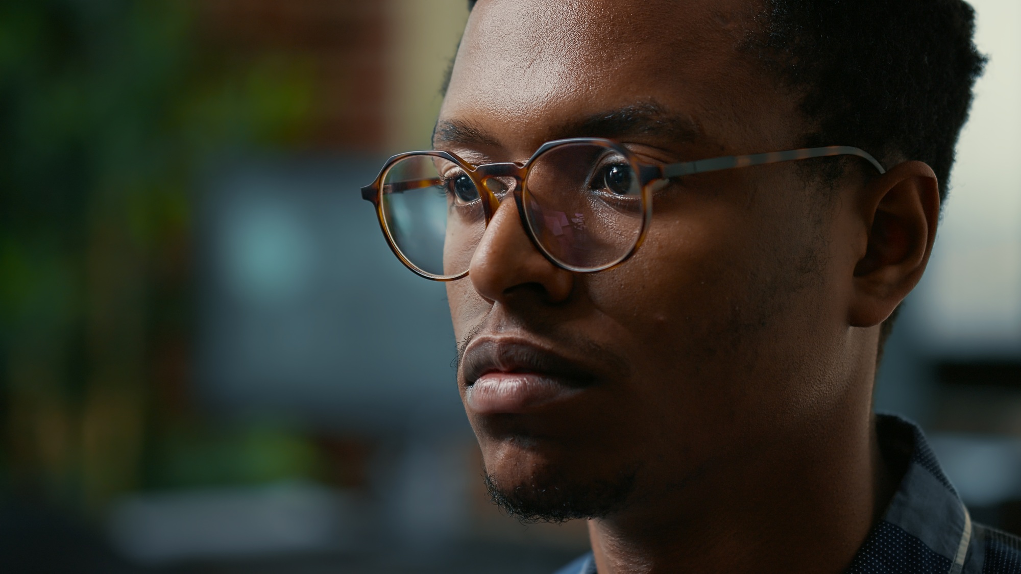 Focus on moving eyes of software developer writing code in front of monitor working focused