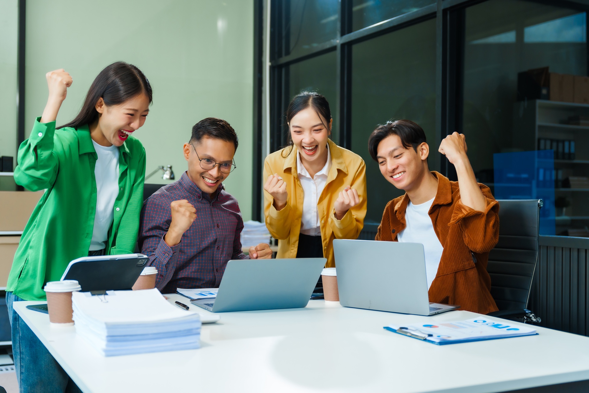 In a boardroom, an Asian team discusses startup financials and business terms.