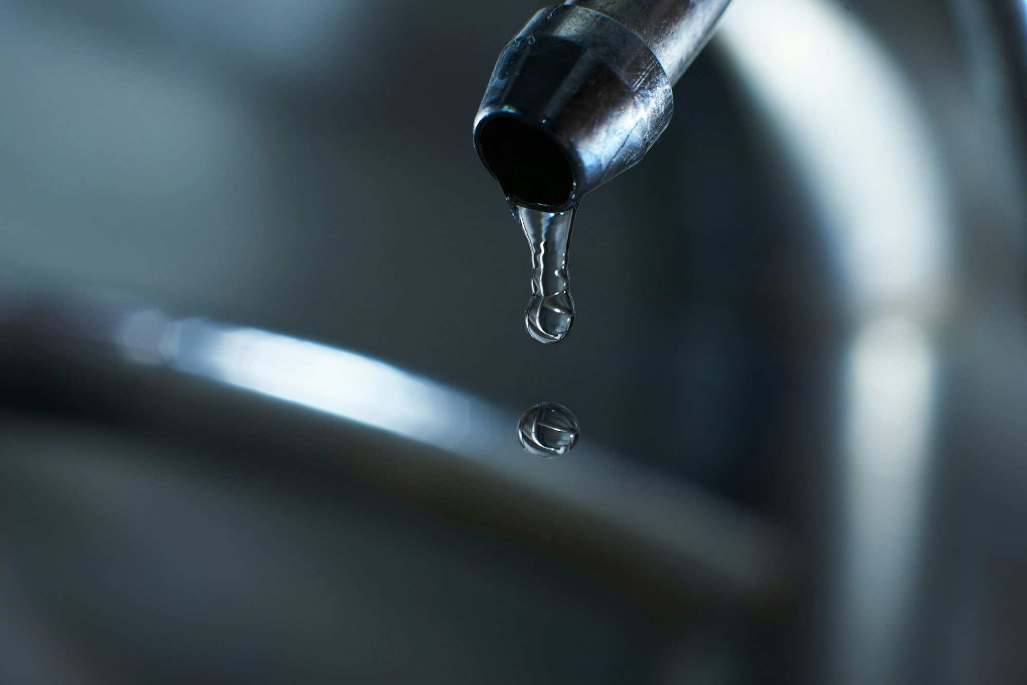 Reverse osmosis filter tap closeup with dripping water-drop.